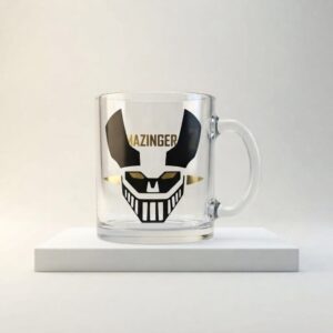 Taza de vidrio transparente con figura de Mazinger Z en vinilo negro y dorado, vista frontal.