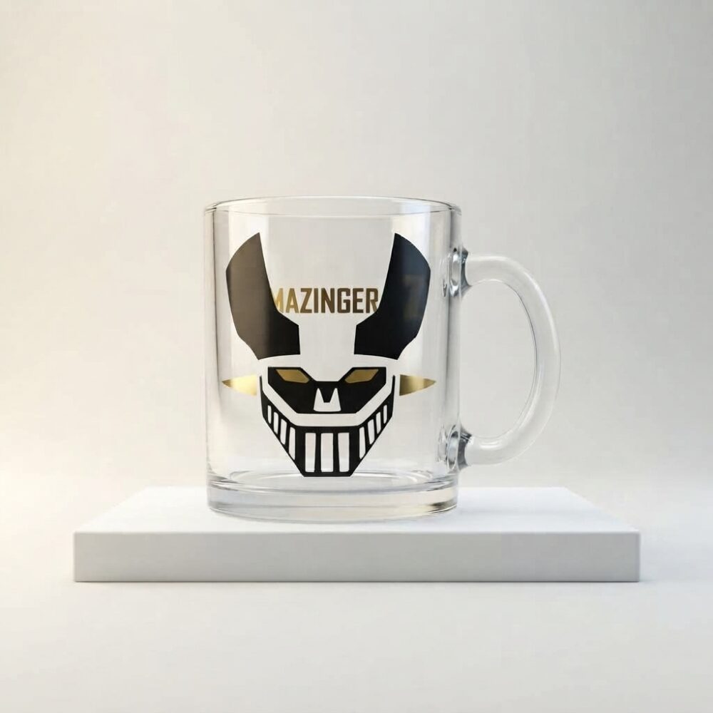 Taza de vidrio transparente con figura de Mazinger Z en vinilo negro y dorado, vista frontal.